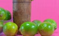 Tahiti lemon juice and fruits Citrus Ãâ latifolia in wooden cup on pink background